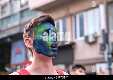 Buenos Aires, Argentinien; 25. August 2022: Junger Mann mit Planet Erde auf seinem Gesicht gemalt, der eine Umweltdemonstration anschrie. Stockfoto