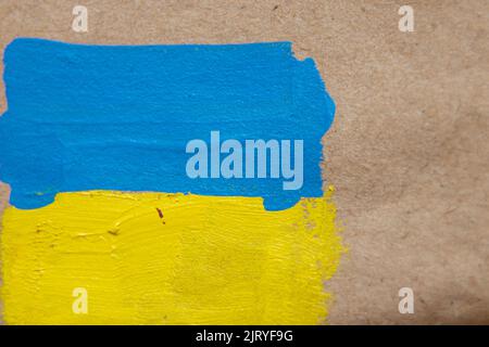 Die Flagge der Ukraine ist mit Farben auf braunem Papier, Tapete gemalt Stockfoto