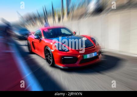 Dynamisches Foto mit Zoom-Effekt von Sportwagen-Rennwagen rot Porsche Cayman GT4 Verlassen der Boxengasse, FIA Formel 1 Strecke, Circuit de Spa Francorchamps Stockfoto