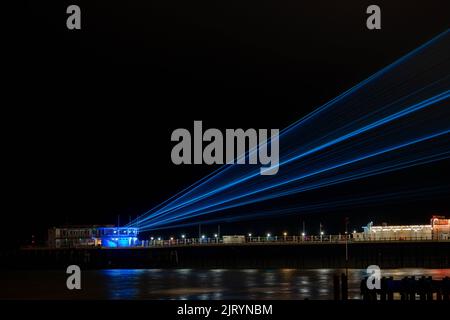 Lasershow am worthing Pier West Sussex bei Nacht mit Reflexionen bei Flut Stockfoto