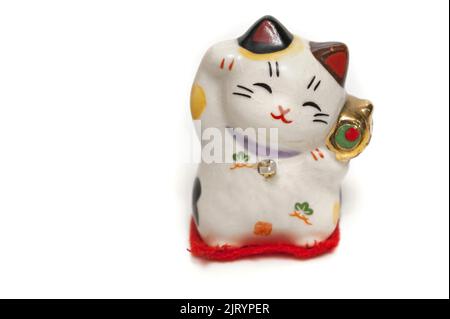 Ein Maneki-Neko, glückliche Katze, winkend mit einer aufrechten Pfote, japanisches Souvenir isoliert Stockfoto