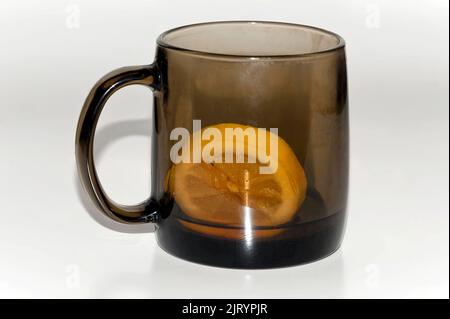 Isolierte fast leere Tasse Tee mit Zitrone Stockfoto