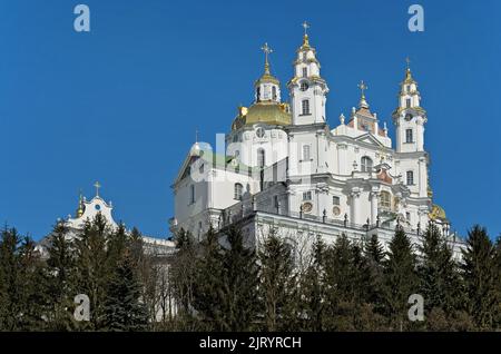 Dormition Kathedrale der Heiligen Dormition Pochayiv Lavra, Ukraine über dem Kiefernwald gesehen. Stockfoto