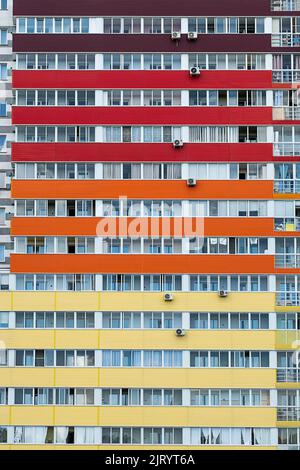 Mehrfarbige Hochhausfassade. Städtischer Immobilienhintergrund. Stockfoto