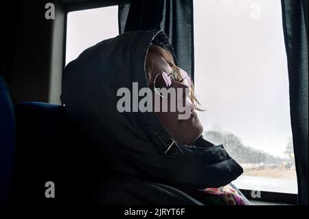 Der Tourist in der Haube in der Nähe des Fensters im Bus in Ternopil Ukraine Stockfoto