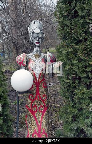 Lamppost mit Blick auf die weibliche Steampunk-dekorative Statue, die Lampe im Hof des Bierrestaurants Kovcheg (Ark) in Ternopil, Ukraine hält Stockfoto