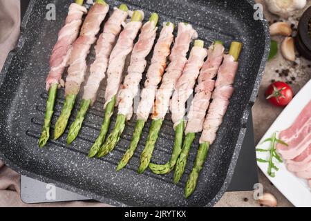 Gesunde Ernährung - Spargel mit Speck und Gewürzen auf der Grillpfanne eingewickelt Stockfoto
