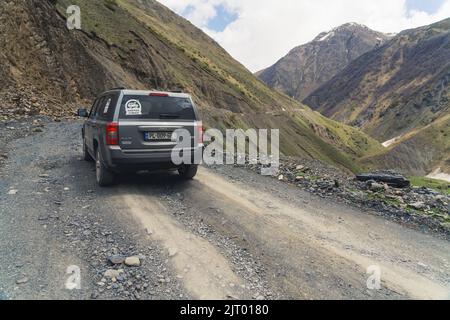 14.05.2022. Kazbegi, Georgien. Auto fährt auf der Bergstraße. Hochwertige Fotos Stockfoto