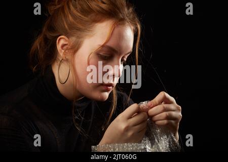 Gestresste Frau in Depression platzt Blasen der Verpackung Cellophan Stockfoto