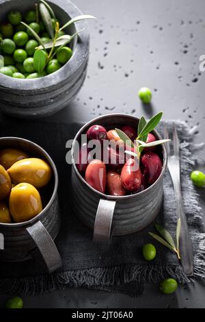 Verschiedene Arten von Oliven in Schalen bereit zu essen. Konserven aus Oliven. Stockfoto