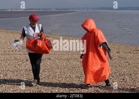 Ein Care4Calais-er Wohltätigkeitsarbeiter (links) mit einem Mann, der nach einem Vorfall im Kanal mit einem kleinen Boot an Bord eines RNLI-Rettungsboots nach Dungeness, Kent, gebracht wurde, dachte an einen Migranten. Bilddatum: Samstag, 27. August 2022. Stockfoto