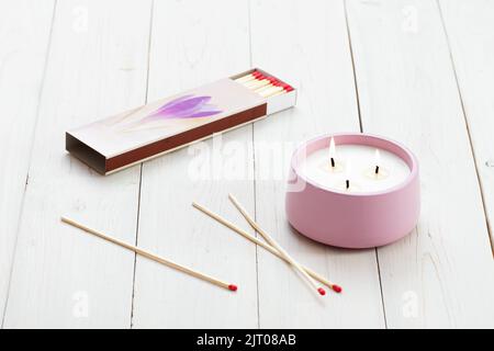 Brennende Kerzen und verstreute Streichhölzer auf einem Holztisch. Inneneinrichtung. Stockfoto