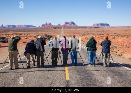 Eine Gruppe von Fotografen in einem Fotoworkshop, die Fotos von der Straße zum Monument Valley an der Grenze zwischen Utah und Arizona machen. Hinweis: Ein Spotter beobachtete Stockfoto