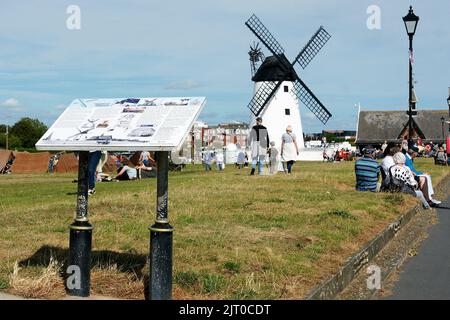 Informationstafel und Windmühle auf Lytham Green Stockfoto