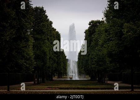 Hannover, Deutschland. 27. August 2022. Ein Wasserbrunnen auf dem Gelände des Herrenhausener Gartens schießt bei bewölktem Wetter Wasser in die Luft. Quelle: Moritz Frankenberg/dpa/Alamy Live News Stockfoto