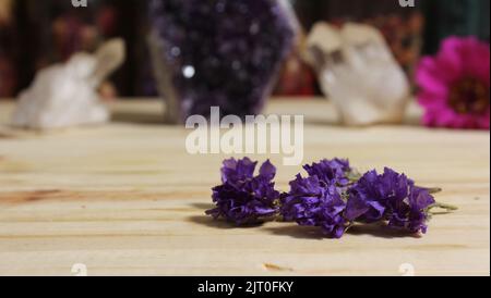 Amethyst-Kristalle mit Blumen auf Meditationsaltar Stockfoto