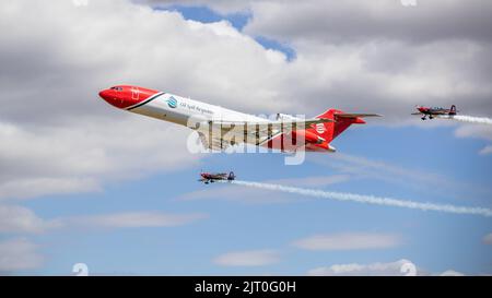 Boeing 727-2S2F Oil Spill Response-Flugzeug, das einen speziellen Formationsflypast mit 2 Extra 300s vom Rotorblätter-Kunstflugteam auf der RIAT 2022 durchführt Stockfoto