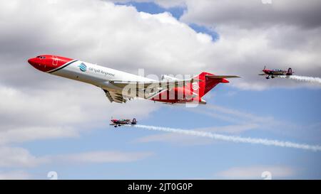 Boeing 727-2S2F Oil Spill Response-Flugzeug, das einen speziellen Formationsflypast mit 2 Extra 300s vom Rotorblätter-Kunstflugteam auf der RIAT 2022 durchführt Stockfoto