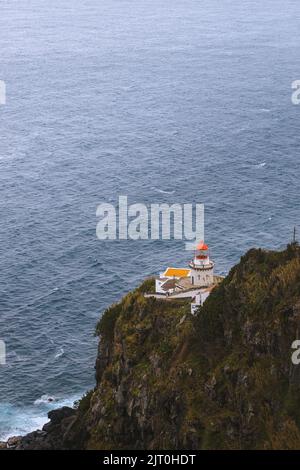 Dramatischer Blick auf den Leuchtturm auf Ponta do Arnel, Nordeste, Sao Miguel Island, Azoren, Portugal. Stockfoto