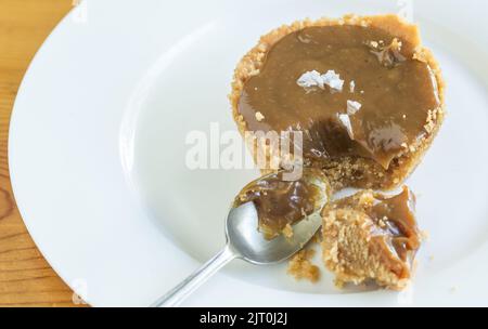 Gesalzene Karamelltarte wird gegessen - Foto mit Platz für Kopien Stockfoto