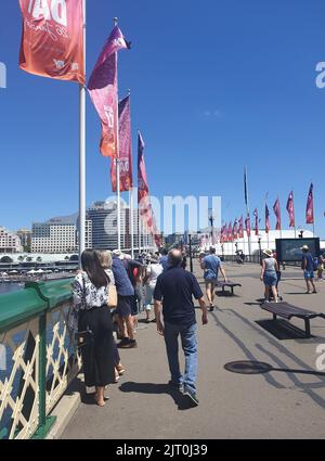 Eine Vertikale von Menschen, die am Darling Harbour in Sydney, Australien, spazieren gehen Stockfoto