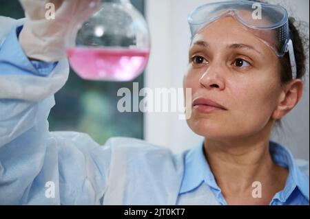 Nahaufnahme Wissenschaftler arbeitet mit Flüssigkeiten in Laborartikeln, analysiert Kolben mit flüssiger Substanz in einem chemischen Forschungslabor Stockfoto