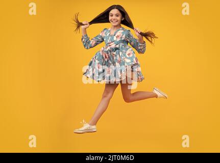 Ein erstaunlicher Teenager. In voller Länge überglücklich Teenager Kind Mädchen 12 13 14 Jahr in Freizeitkleidung springen alt isoliert auf gelbem Hintergrund Studio. Witziger Sprung Stockfoto