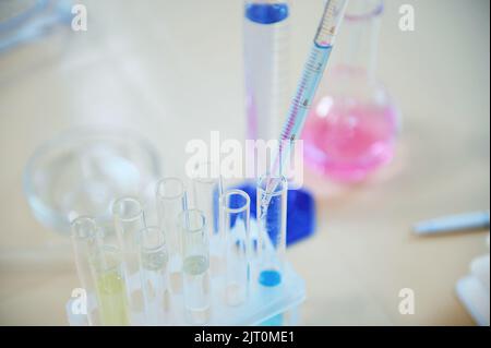 Selektiver Fokus auf Laborglas mit Chemikalien und Reagenzien auf dem Tisch im wissenschaftlichen Forschungslabor. Stillleben Stockfoto