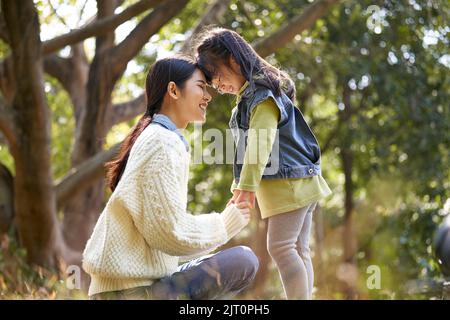 Junge asiatische Mutter und Vorschultochter genießen die Natur mit einer guten Zeit im Park Stockfoto