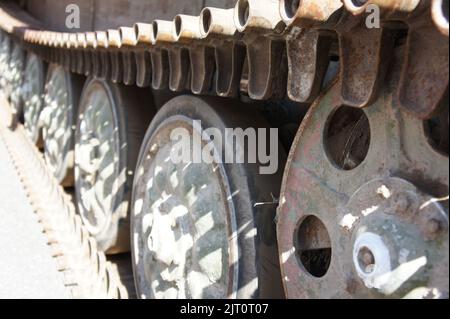 Tankspur. Blick auf den vorderen Teil der grünen Raupe des Tanks, der mit den Rädern aus der Nähe auf dem Boden steht Stockfoto