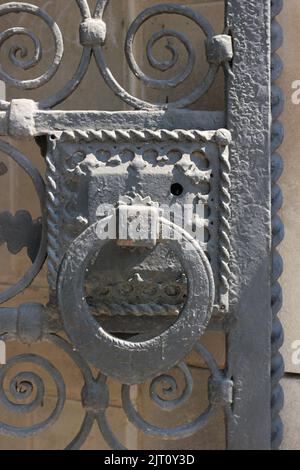 Riesiger schwerer Türklopfer an einer gusseisernen Metalltürwand. Stockfoto