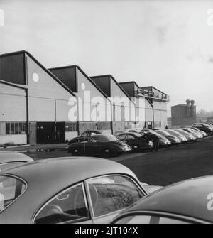 Porsche Geschichte. Eine seltene Ansicht der Porsche-Autofabrik in Stuttgart Deutschland im Jahr 1950s. Auf dem Werksgelände sind Porsche-Fahrzeuge in verschiedenen Produktionsstufen zu sehen. Das Emblem von Porsche ist auf dem Fabrikgebäude zu sehen. 1951. Stockfoto