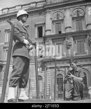 Fotograf im Jahr 1950s. Ein kleiner Junge mit seiner Kamera im Hof des königlichen Schlosses in Stockholm macht ein Bild des Burgwächters, der in Uniform und Waffe steht. Schweden 1951 Conard Ref. 2443 Stockfoto