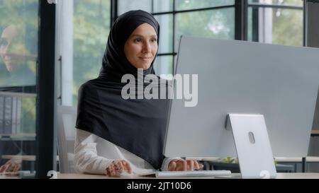 Selbstbewusst erfolgreiche elegante arabische Geschäftsfrau Eingabe auf Computer Attraktive muslimische Frau in Hijab professionelle Arbeiter erfahrene Manager Stockfoto