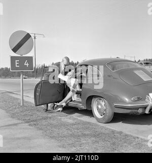 Paar in der 1960s. Ein junges Paar in ihrem Porsche-Sportwagen hat auf der Straße angehalten, um die Karte zu studieren, wo es hingeht. Schweden 1962 Stockfoto