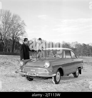 In der 1960s. Ein Paar im Winter mit ihrem brandneuen Auto, einem DKW Junior. Deutscher Automobilhersteller, der auch Motorräder herstellt, gehört zur Auto Union. Sie sehen glücklich aus und sind in warme Winterkleidung gekleidet. Schweden 1961. Stockfoto