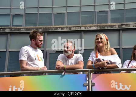 Manchester, Großbritannien. 27.. August 2022. Die Teilnehmer auf dem Oberdeck des ITV Open Top Busses machen sich bereit, an der LGBTQ+ Pride Parade im Zentrum von Manchester, Großbritannien, teilzunehmen, da LGBTQ+ Pride vom 26.. Bis 29.. August über das Wochenende an den Bankfeiertag weitergeht. Quelle: Terry Waller/Alamy Live News Stockfoto