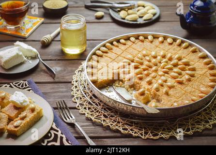 Arabische Küche; traditionelles arabisches Dessert „Basbousa“. Ägyptischer orientalischer Grießkuchen mit goldener knuspriger Mandel. Stockfoto