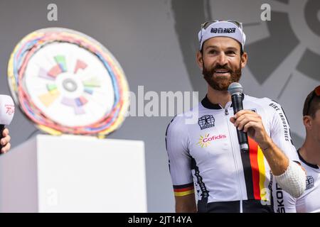 Freiburg Im Breisgau, Deutschland. 27. August 2022. Simon Geschke steht vor der dritten Etappe der Deutschlandtour in Freiburg am Start und spricht ins Mikrofon. Die 3. Etappe der Deutschland-Rundfahrt führt von Freiburg über den Breisgau und das Markgräfler Land ins Schauinsland. Quelle: Philipp von Ditfurth/dpa/Alamy Live News Stockfoto