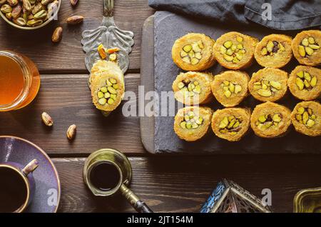 Arabische Küche, traditionelles Gebäck aus dem Nahen Osten und das berühmte Dessert „Kunafa“ im Ramadan mit gerösteter Pistazie. Stockfoto