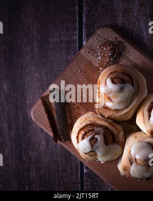 Hausgemachte Zimtrollen auf Holzbrett Stockfoto