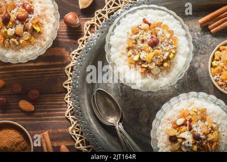 Arabische Küche; Nahost-leckerer cremiger Reispudding mit Zimt und Nüssen. Stockfoto
