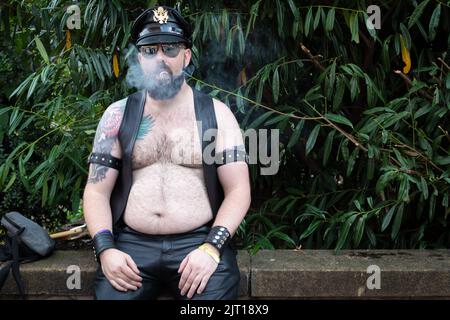 Manchester, Großbritannien. 27. August 2022. Ein Mann ruht nach der diesjährigen Pride Parade. In diesem Jahr wird die Parade zum ersten Mal seit 2019 wieder voll ausgelastet. Kredit: Andy Barton/Alamy Live Nachrichten Stockfoto