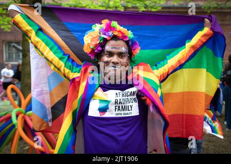 Manchester, Großbritannien. 27. August 2022. Ein Mitglied des afrikanischen Regenbogens genießt den Abschluss der Pride Parade. In diesem Jahr wird die Parade zum ersten Mal seit 2019 wieder voll ausgelastet. Kredit: Andy Barton/Alamy Live Nachrichten Stockfoto