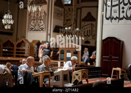 BURSA, TÜRKEI - 21. AUGUST: Innenansicht der Großen Moschee (Ulu Cami) am 21. August 2022 in Bursa, Türkei. Muslime rezitieren den Koran im Inneren des mosq Stockfoto