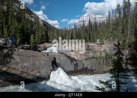 Langzeitbelichtung an der Naturbrücke mit starkem Fluss und Bergen in den Rockies Stockfoto