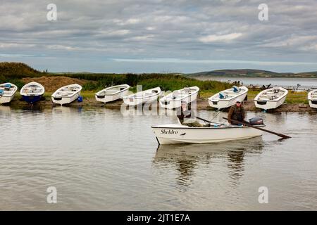 Loch Harray, Orkney, Großbritannien. 27. August 2022. Die zurückkehrenden Fliegenfischer spiegeln sich in den ruhigen Gewässern von Loch Harray, Orkney, Großbritannien, wider. Die Angler, deren Preisfang die Bachforelle ist, sind bis zu sechs Stunden am Tag auf dem Wasser. Kredit: Peter Lopeman/Alamy Live Nachrichten Stockfoto