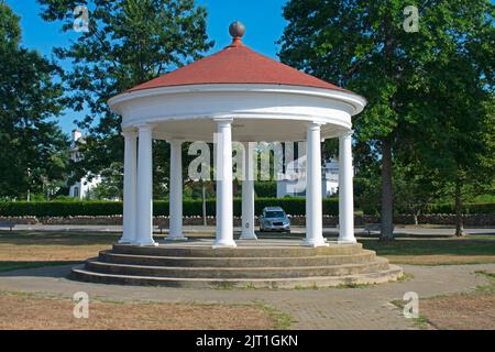 Blick durch den Pavillon im historischen Kings Park, Newport, Rhode Island, auf ein einzelliges geparktes Fahrzeug und eingezäunte Häuser auf der anderen Seite der Straße -0 Stockfoto