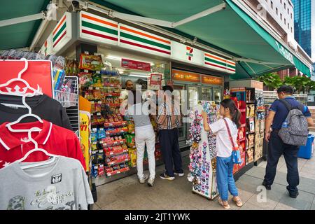 SINGAPUR – CIRCA JANUAR 2020: Menschen, die in einem 7-11-Laden in Singapur Schlange stehen. Stockfoto