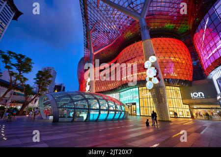 SINGAPUR - CA. JANUAR, 2020: Straßenansicht des ION Orchard Einkaufszentrums in Singapur am Abend. Stockfoto